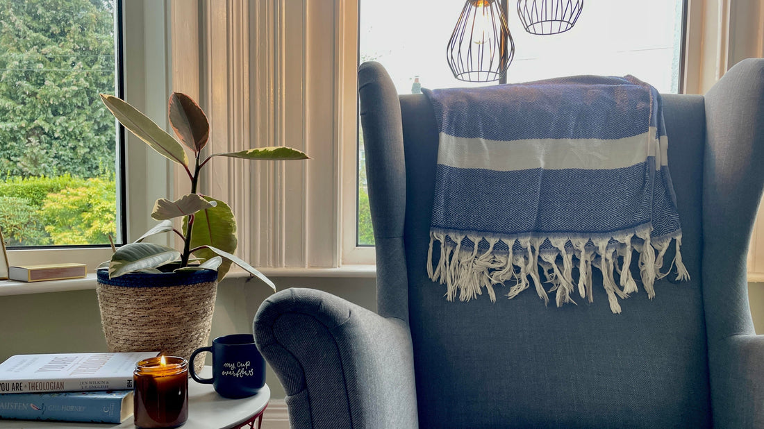 cosy minimal home for autumn winter with blue wingback chair and flickering candle