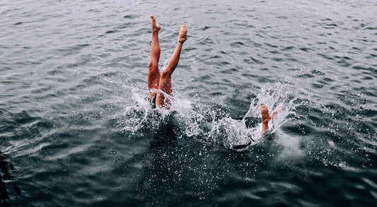 legs poking out of the sea surrounded by splashing water