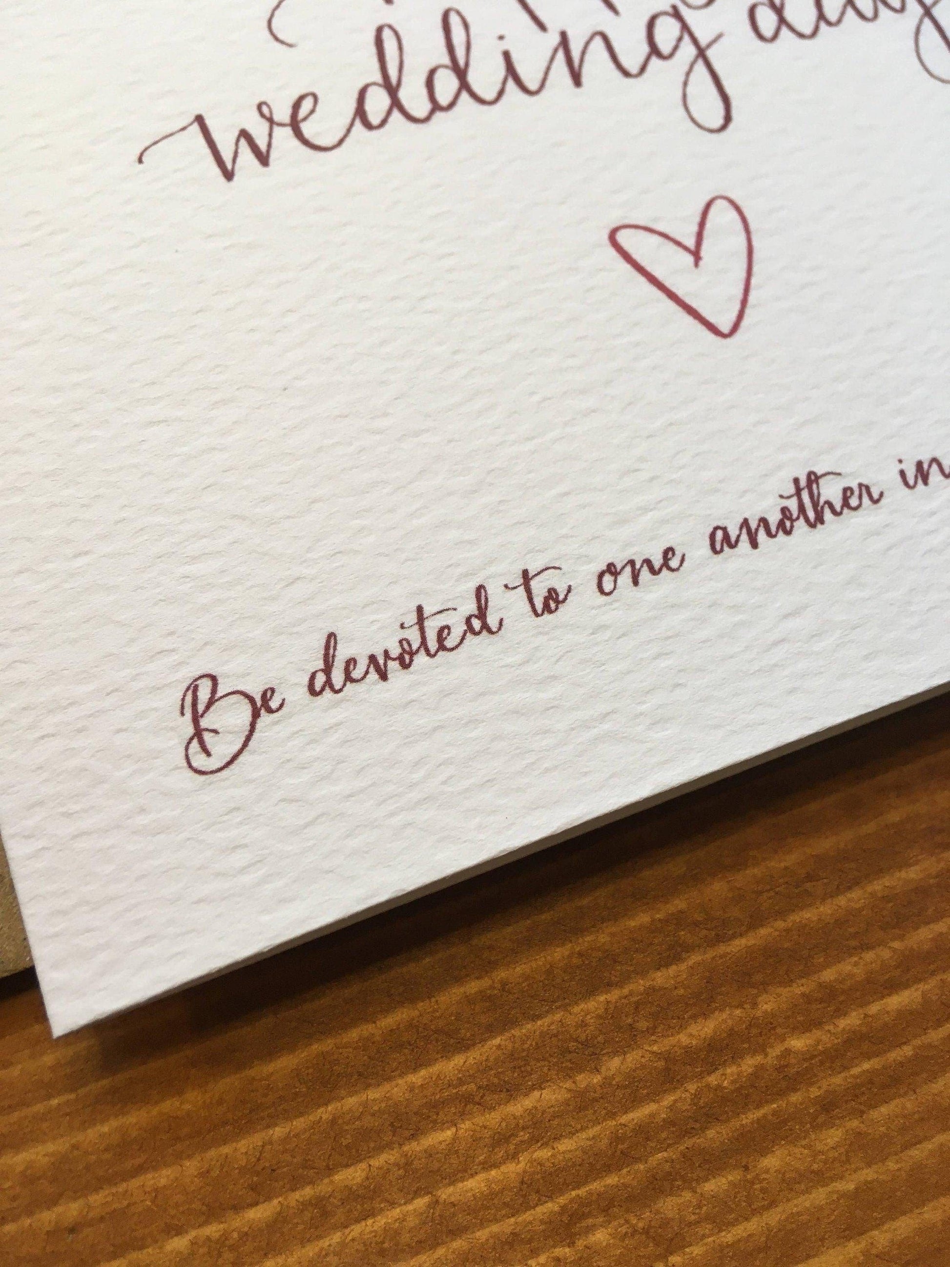 Hand lettered Romans 12:10 Bible verse on wedding card