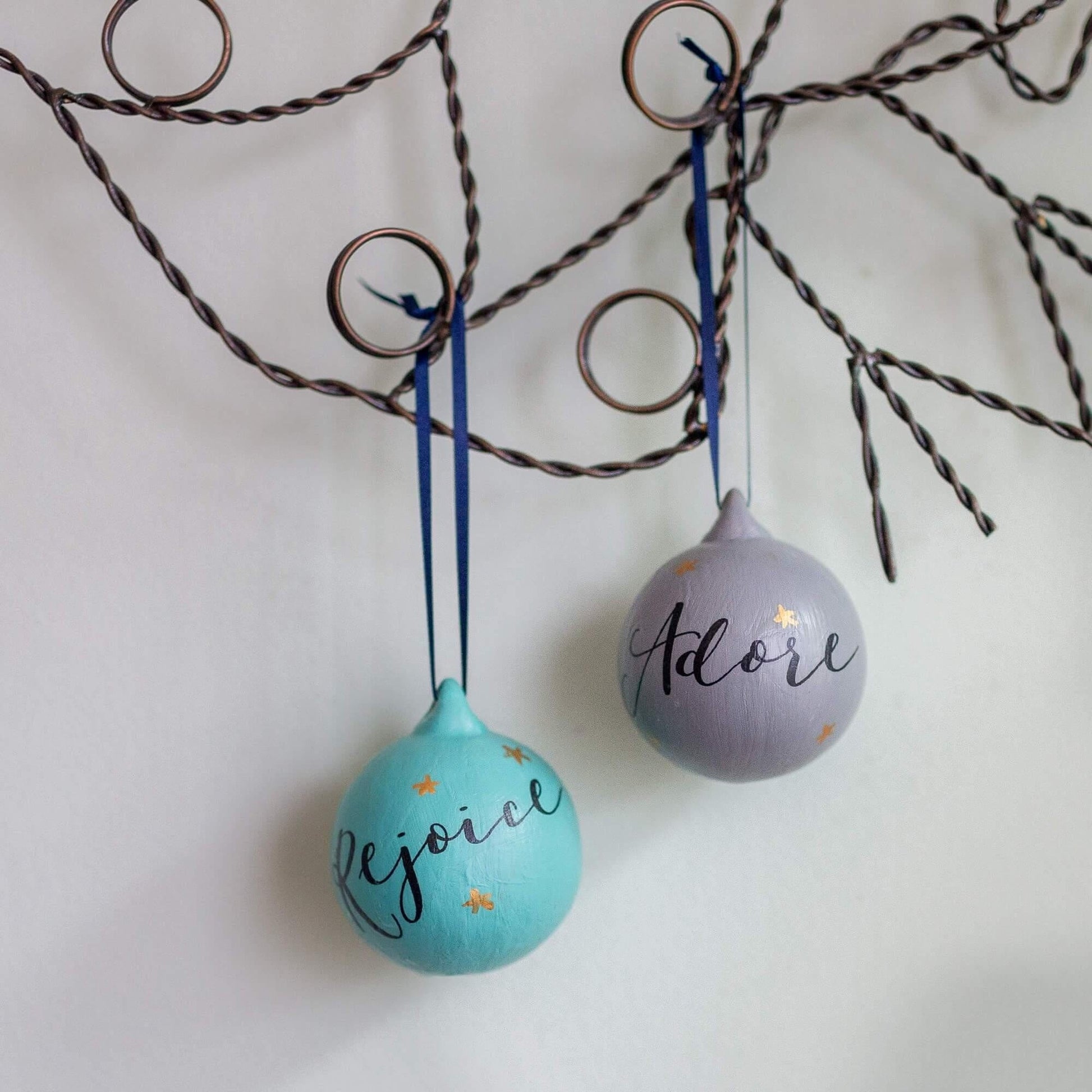 Mint green and light grey ceramic baubles with calligraphy words