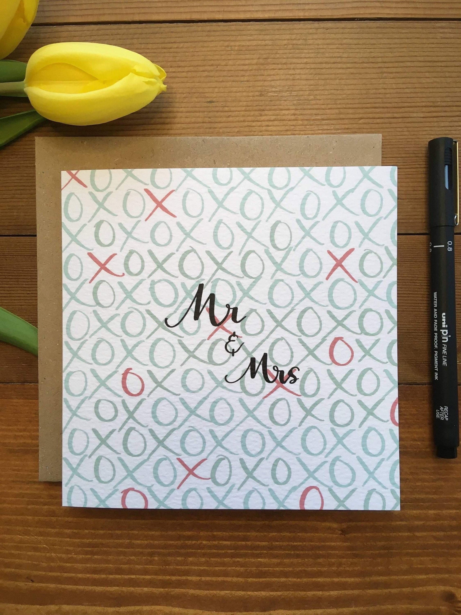 Luxury wedding card for mr & Mrs with pale blue X’s and O’s on the bsckground